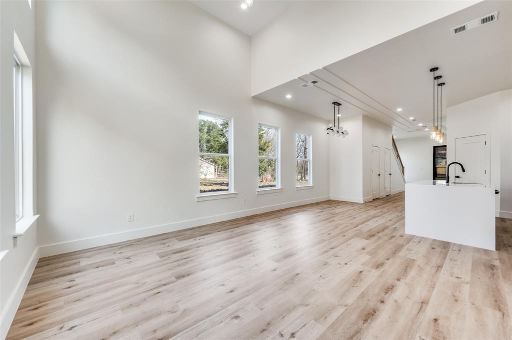 407 Bobbie Street Dallas, TX 75203 - Photo 9 of 25 an empty room with wooden floor and windows