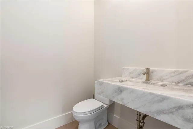 a bathroom with a sink a toilet and mirror