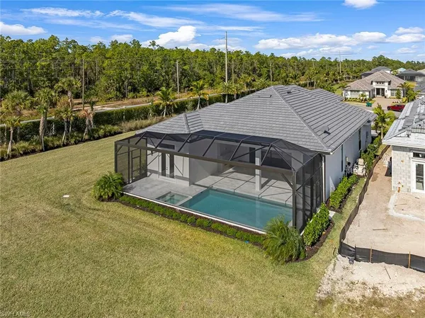 an aerial view of a house with swimming pool garden and mountain view in back