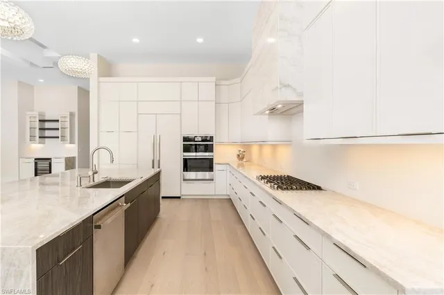a large kitchen with granite countertop a sink and cabinets