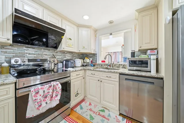 a kitchen with stainless steel appliances granite countertop a sink stove and microwave