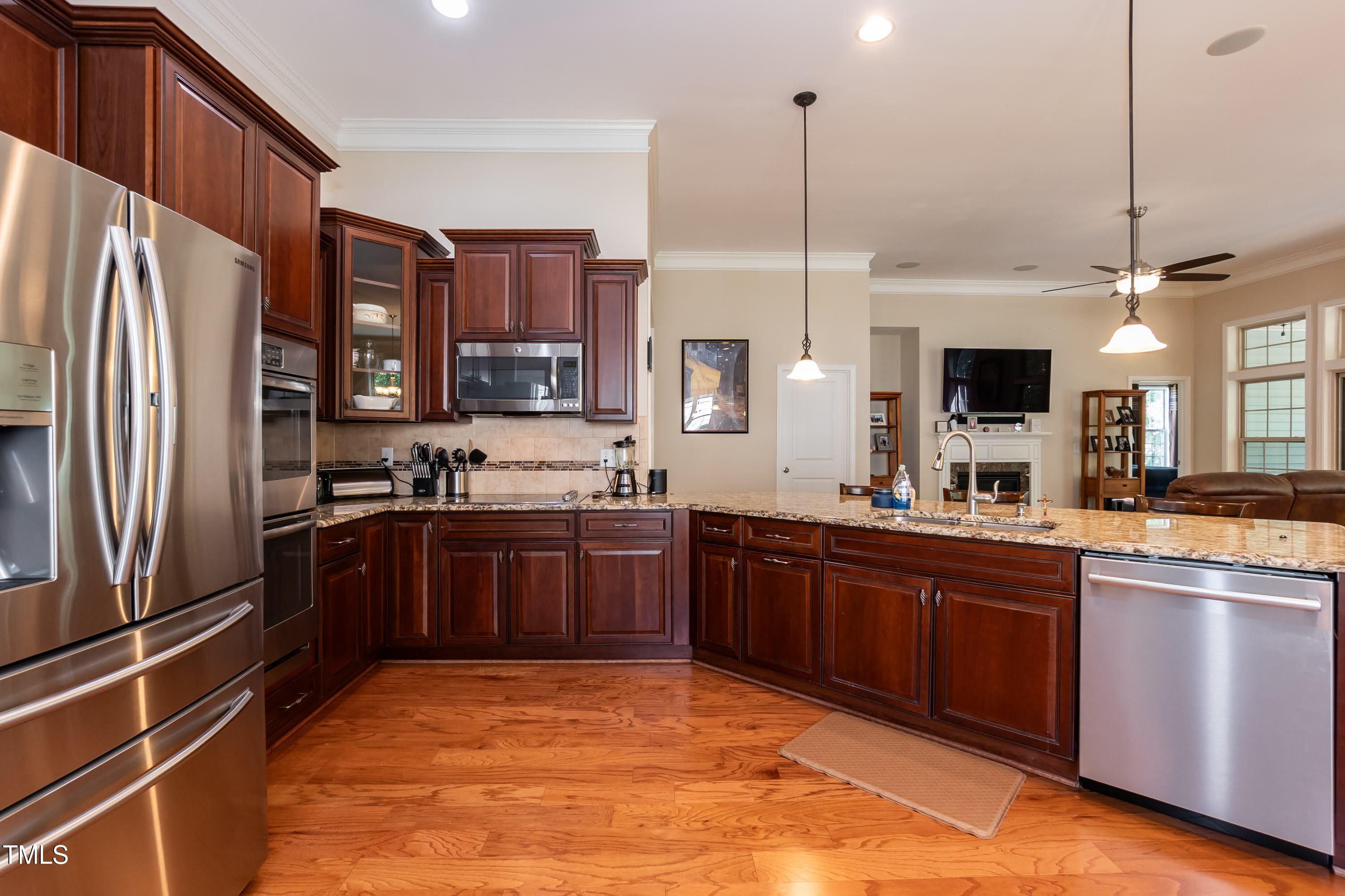 7660 Channery Way Raleigh, NC 27616 - Photo 11 of 42 a kitchen with stainless steel appliances granite countertop a refrigerator a sink dishwasher a oven with wooden cabinets and a stove