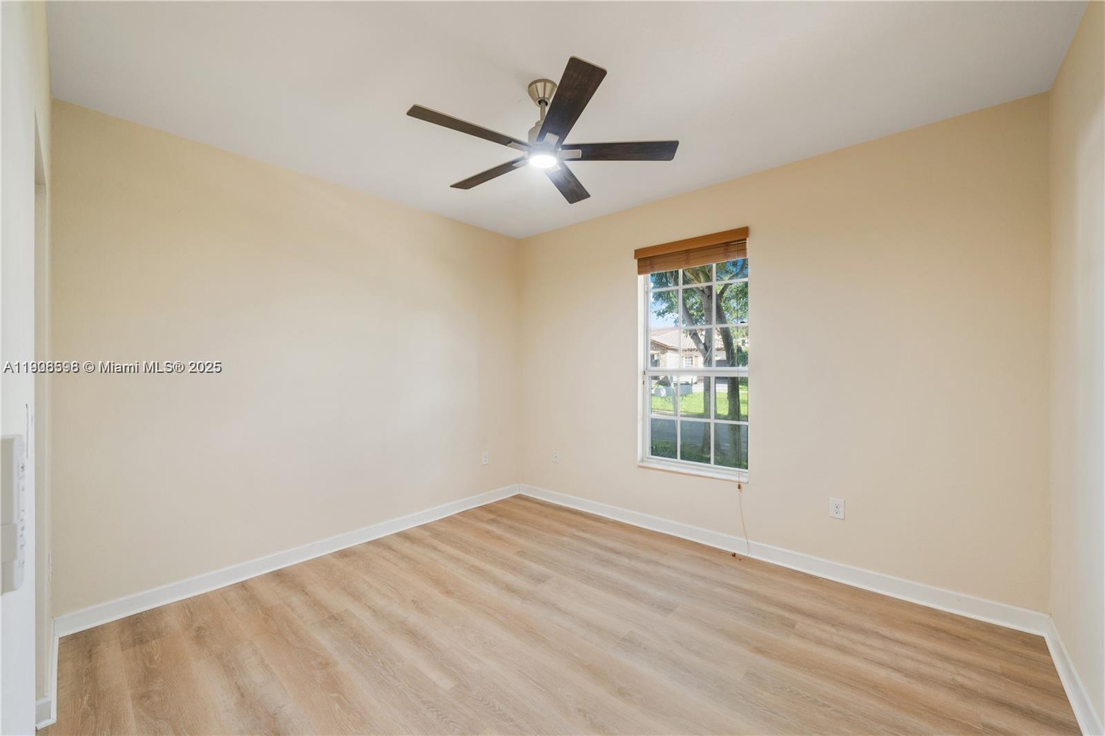 16946 Southwest 90th Terrace Circle Miami, FL 33196 - Photo 14 of 36 a view of empty room with wooden floor and fan