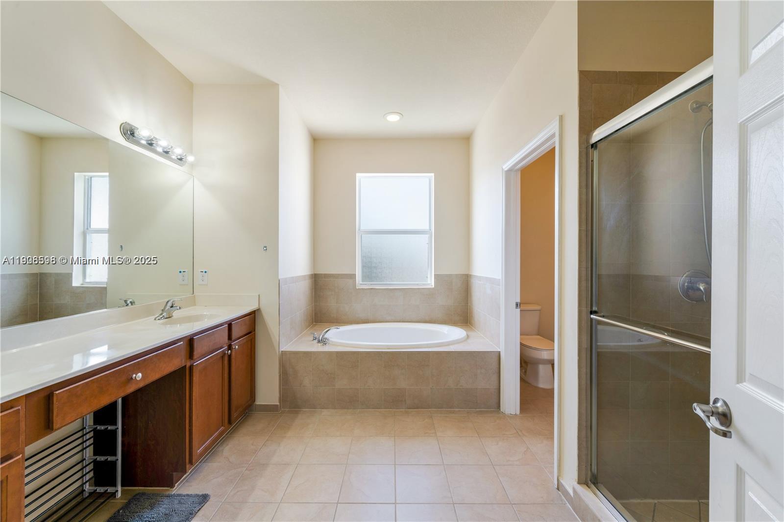 16946 Southwest 90th Terrace Circle Miami, FL 33196 - Photo 19 of 36 a bathroom with a bathtub shower sink and mirror