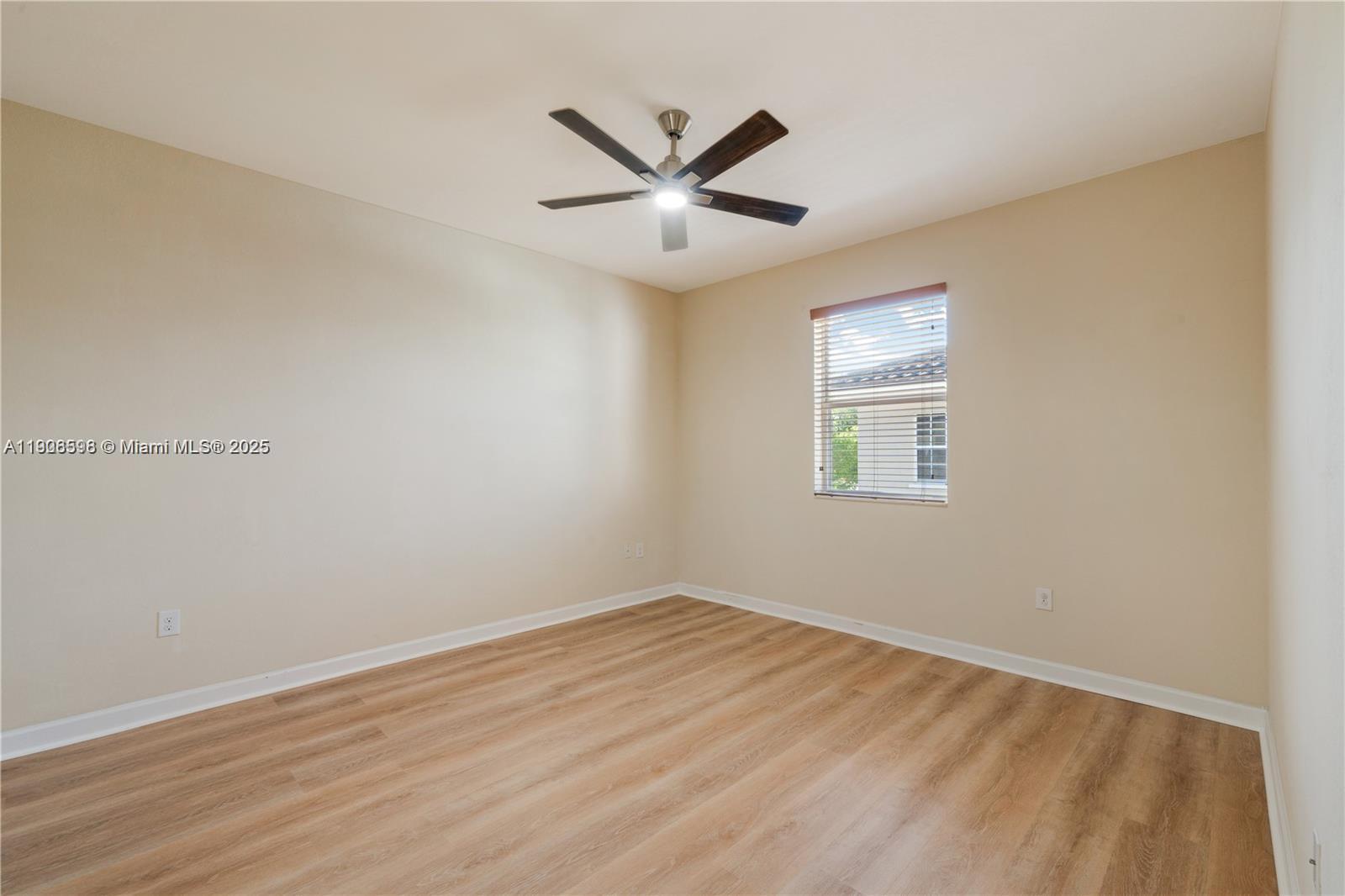 16946 Southwest 90th Terrace Circle Miami, FL 33196 - Photo 25 of 36 an empty room with wooden floor and windows