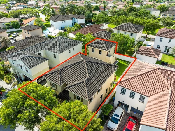 an aerial view of a house with a yard and furniture