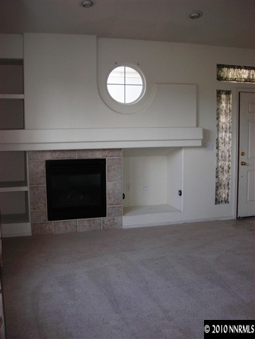 1279 Tule Drive Reno, NV 89521 - Photo 4 of 13 an empty room with a fireplace and a window