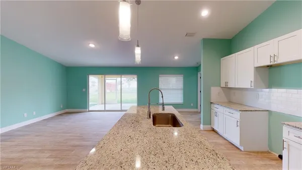 a kitchen with kitchen island sink and refrigerator