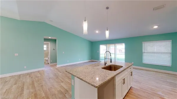 a kitchen with kitchen island a sink a stove and a wooden floors