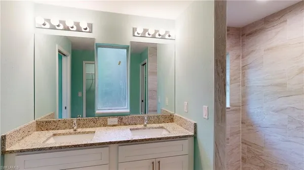 a bathroom with a granite countertop sink and a mirror