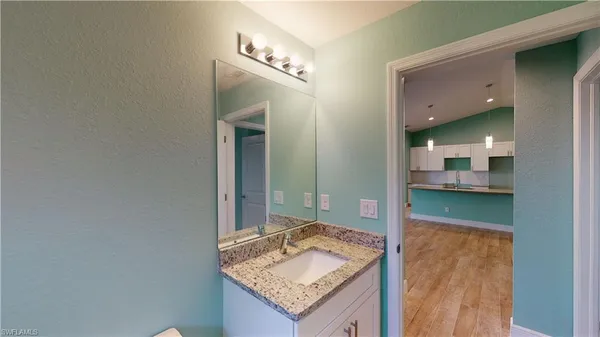 a bathroom with a granite countertop sink and a mirror