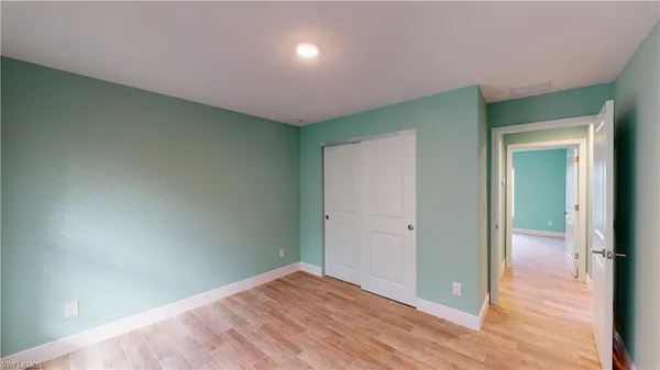 an empty room with wooden floor and closet