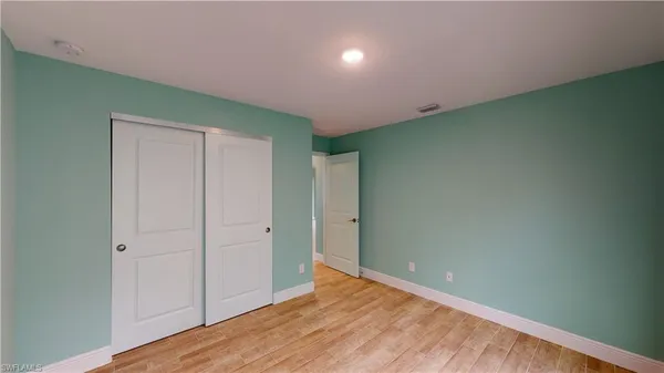 an empty room with wooden floor and closet