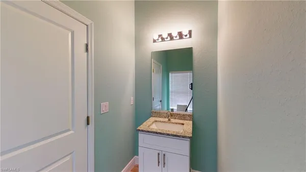 a bathroom with a granite countertop sink and a mirror