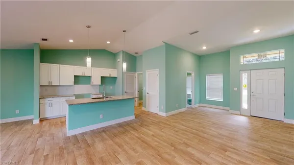 a open kitchen with kitchen island a sink dishwasher stove and refrigerator with wooden floor