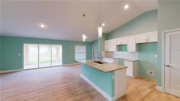 a kitchen with a stove a refrigerator sink and cabinets