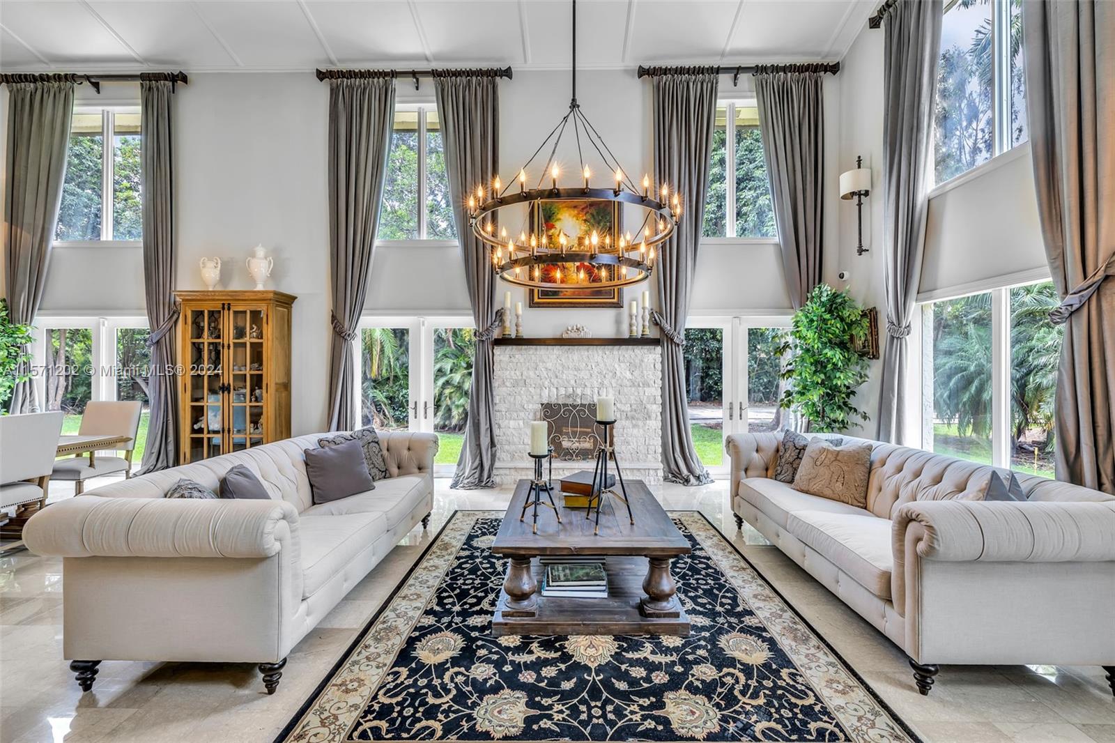 14600 Marvin Lane Southwest Ranches, FL 33330 - Photo 20 of 72 a living room with furniture a fireplace a large window and a chandelier