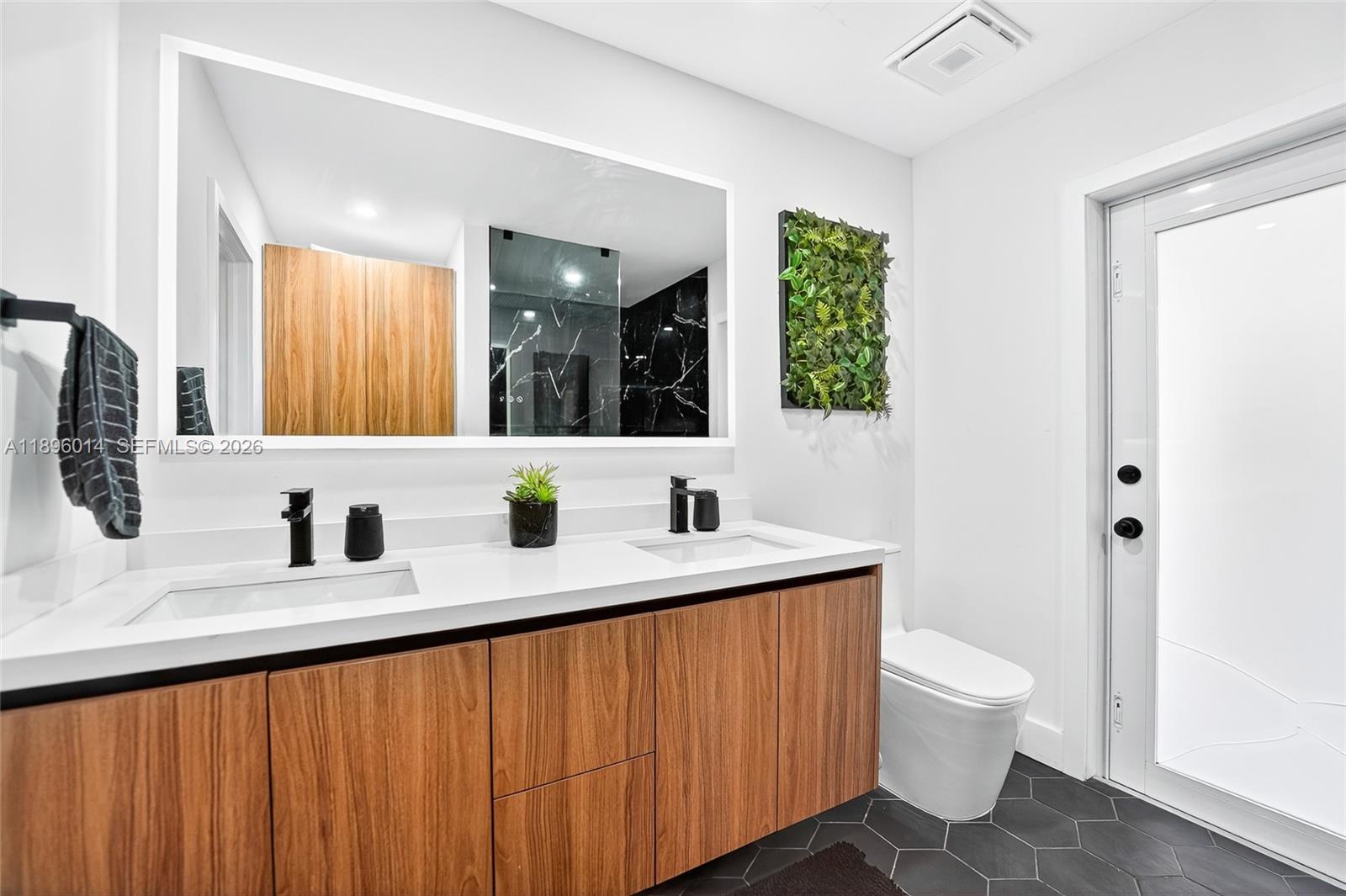752 Northwest 134th Avenue Miami, FL 33182 - Photo 18 of 47 a bathroom with a double vanity sink toilet and mirror