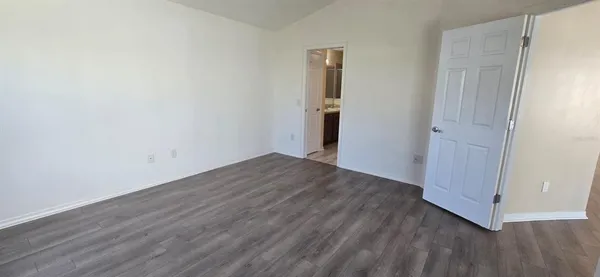 an empty room with wooden floor and entrance