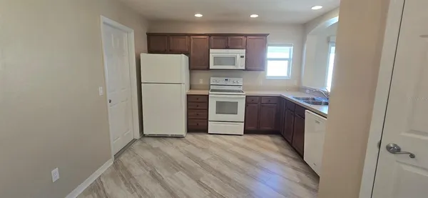 a kitchen with a refrigerator sink and cabinets