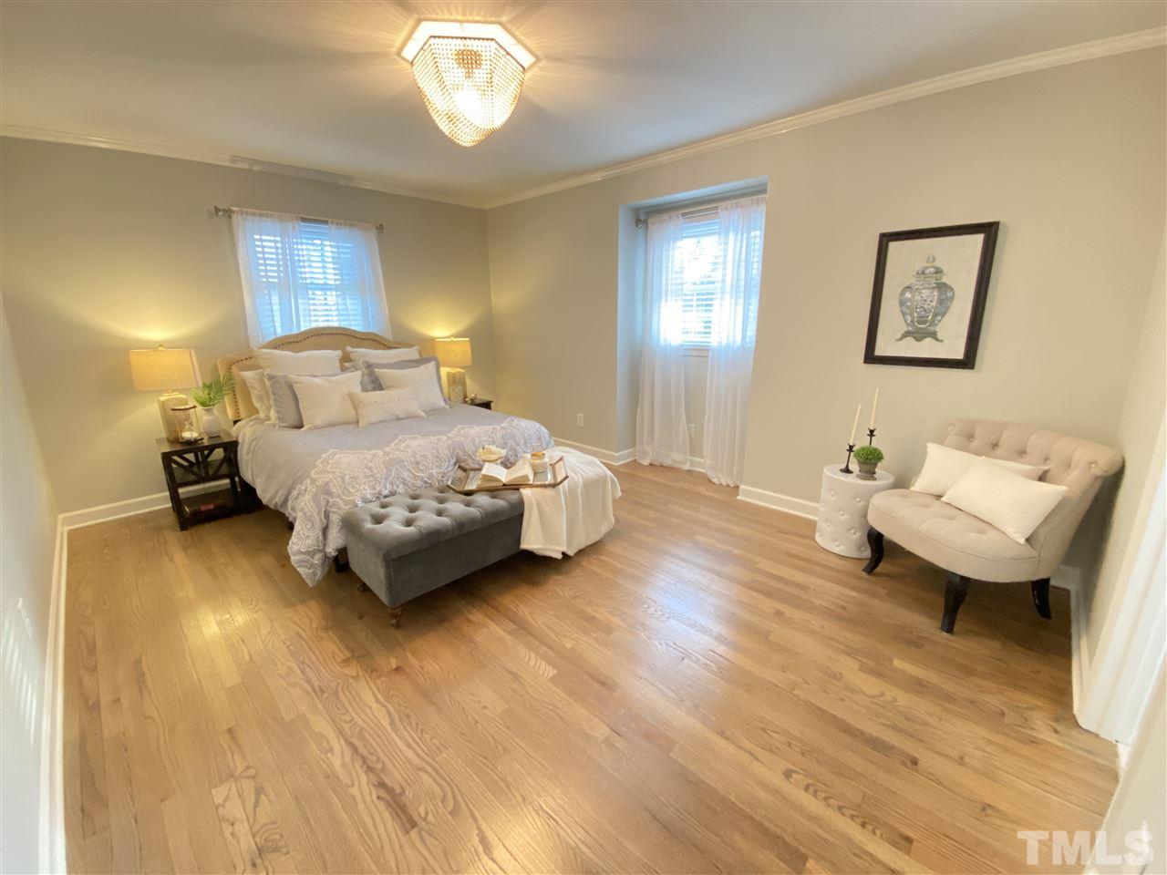 917 Deerfield Road Raleigh, NC 27609 - Photo 11 of 20 a bedroom with a bed and a chandelier