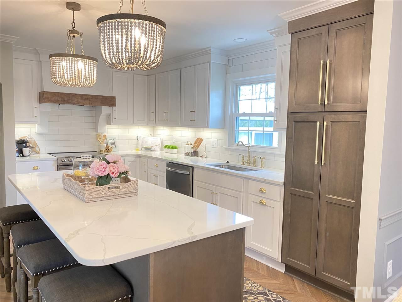917 Deerfield Road Raleigh, NC 27609 - Photo 6 of 20 a kitchen with stainless steel appliances a table chairs and chandelier