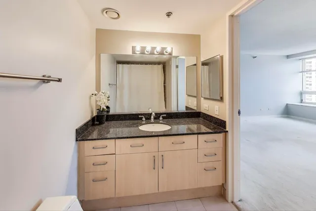 a bathroom with a granite countertop sink and a mirror
