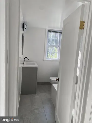 a bathroom with a toilet a sink a tub and mirror