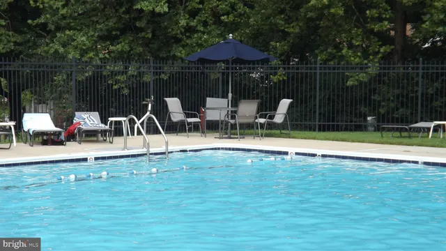 a view of swimming pool with table and chairs under an umbrella