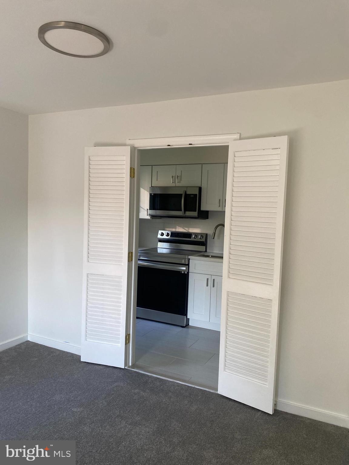 2206 Washington Avenue, Unit 302 Silver Spring, MD 20910 - Photo 4 of 26 a kitchen with granite countertop a stove and a refrigerator