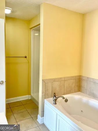 a view of a hallway with wooden floor and a bathroom