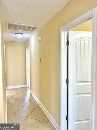 a view of a hallway with a glass door and painted walls