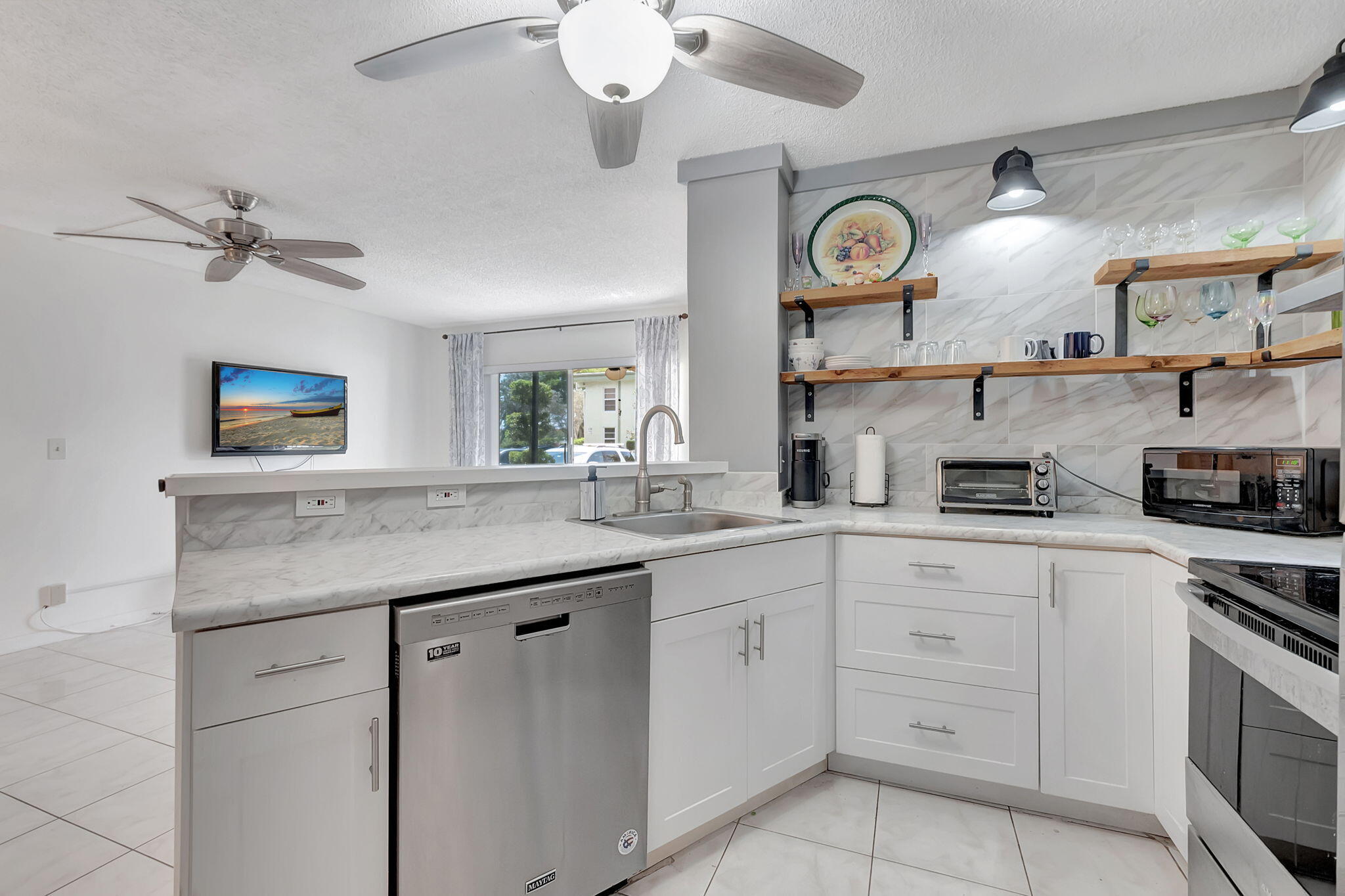 a kitchen with cabinets stainless steel appliances and a clock