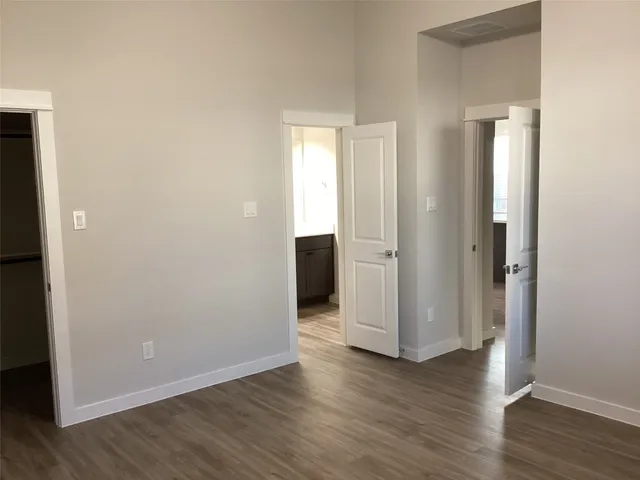 an empty room with wooden floor and closet