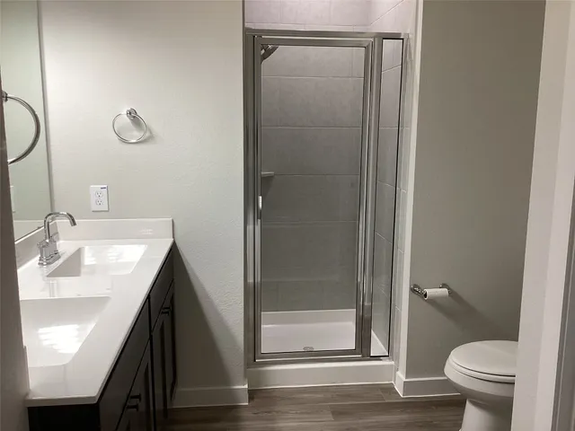 a bathroom with a sink a toilet and shower