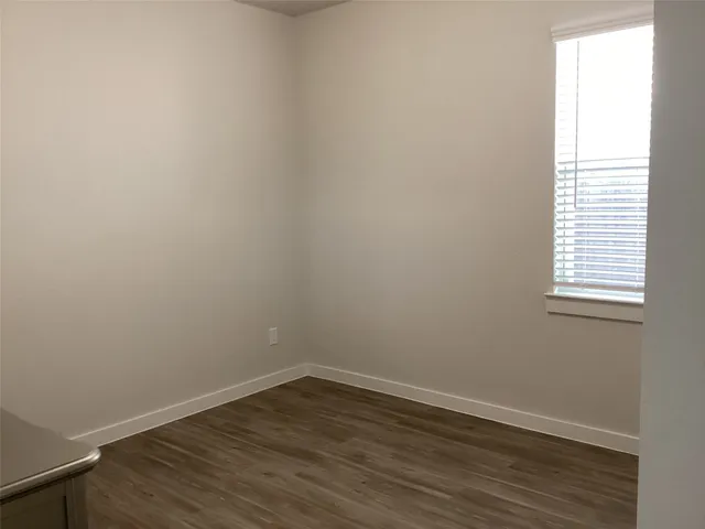 a view of a small space with wooden floor and a window