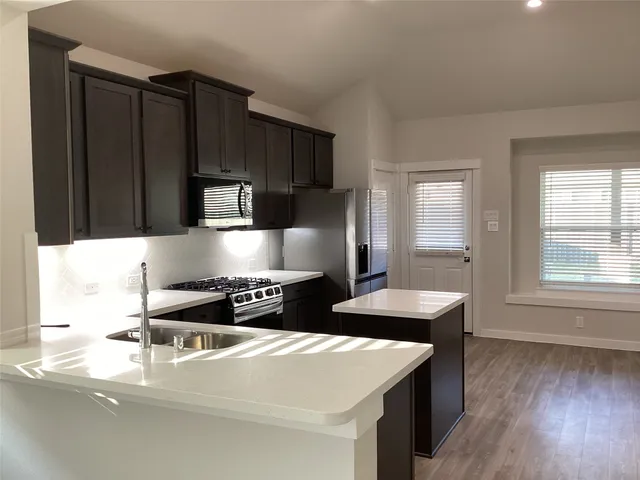 a kitchen with stainless steel appliances a sink stove and cabinets