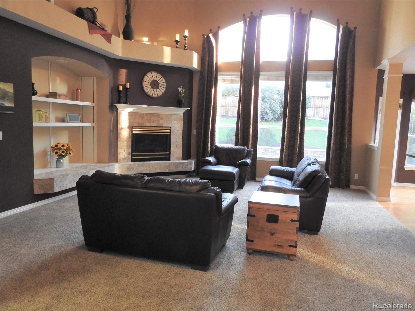 455 West Angus Way Highlands Ranch, CO 80129 - Photo 5 of 27 a living room with furniture a fireplace and a large window
