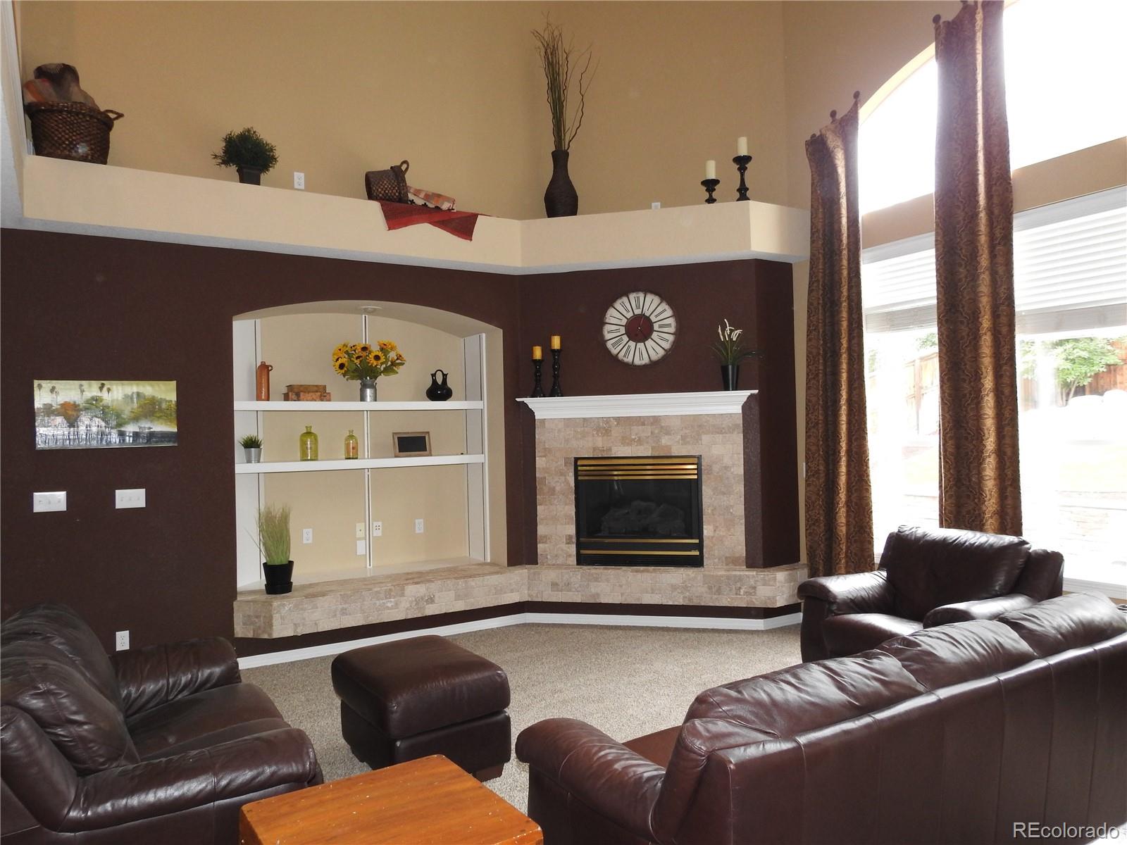 455 West Angus Way Highlands Ranch, CO 80129 - Photo 6 of 27 a living room with furniture and a fireplace
