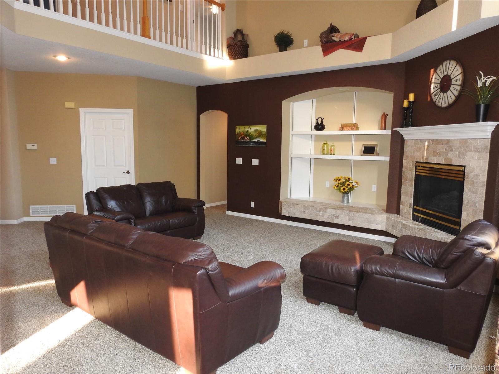 455 West Angus Way Highlands Ranch, CO 80129 - Photo 7 of 27 a living room with furniture and a fireplace