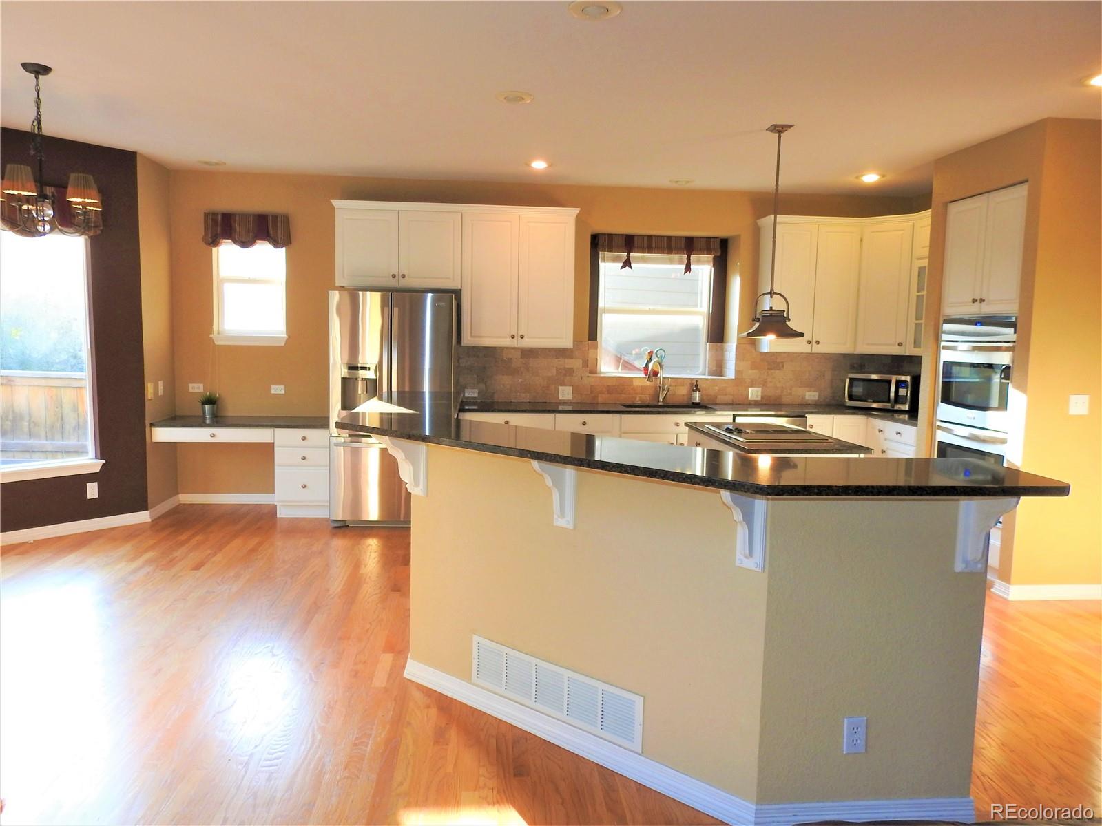455 West Angus Way Highlands Ranch, CO 80129 - Photo 9 of 27 a kitchen with stainless steel appliances granite countertop a stove a sink and a refrigerator