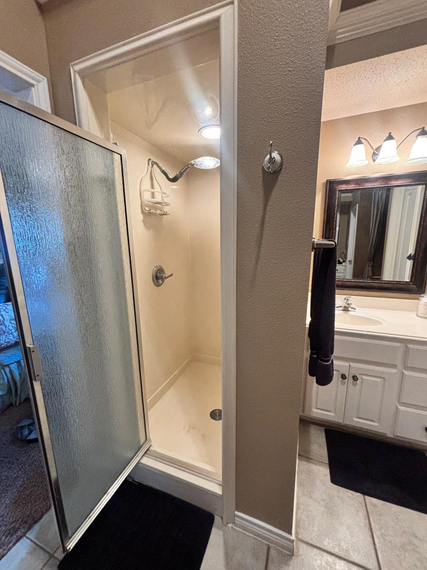 3713 106th Street Lubbock, TX 79423 - Photo 12 of 22 a bathroom with a shower and a mirror