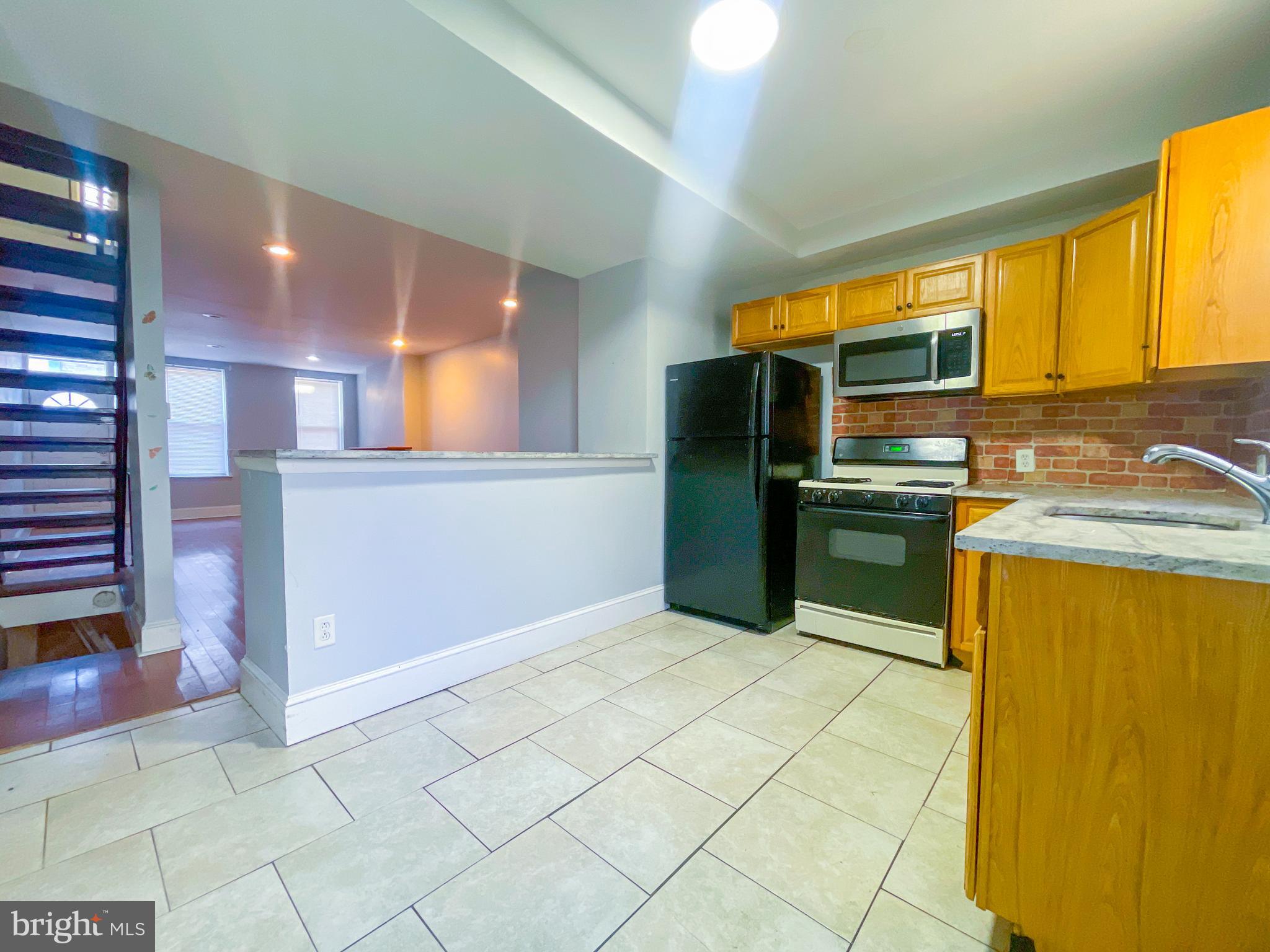 2113 Mountain Street Philadelphia, PA 19145 - Photo 13 of 38 a kitchen with stainless steel appliances granite countertop a sink and a refrigerator