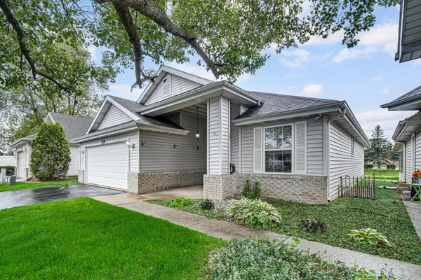 a front view of a house with a garden and yard
