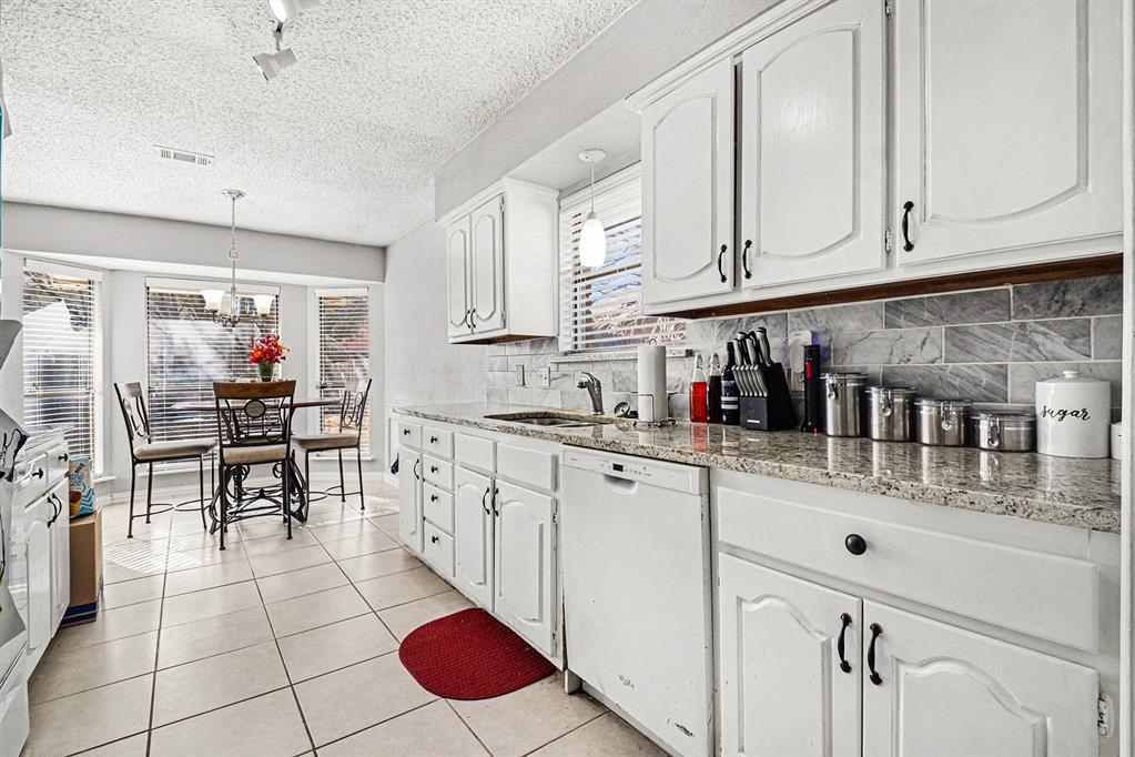 2433 Hallmark Street Grand Prairie, TX 75052 - Photo 3 of 15 a kitchen with stainless steel appliances granite countertop a sink and cabinets