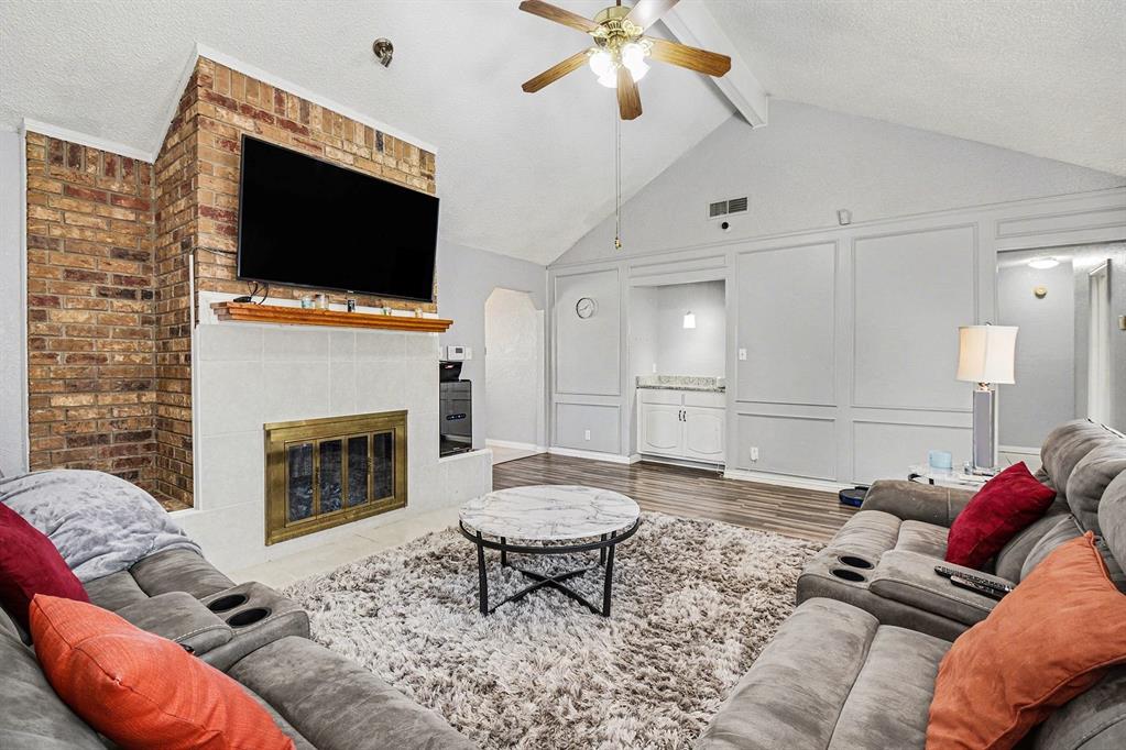 2433 Hallmark Street Grand Prairie, TX 75052 - Photo 5 of 15 a living room with furniture a flat screen tv and a fireplace