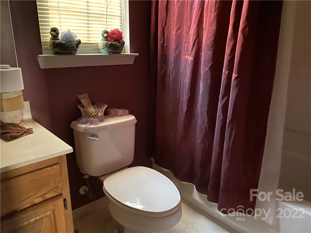 7306 Reedy Creek Road Charlotte, NC 28215 - Photo 12 of 15 a bathroom with a toilet a sink and a window