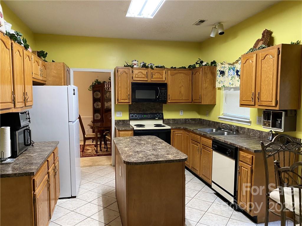 7306 Reedy Creek Road Charlotte, NC 28215 - Photo 5 of 15 a kitchen with stainless steel appliances granite countertop a stove top oven a sink and dishwasher