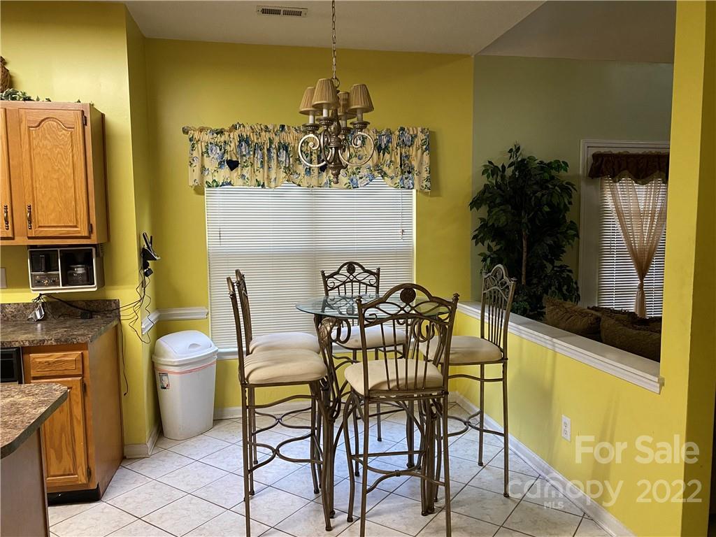 7306 Reedy Creek Road Charlotte, NC 28215 - Photo 6 of 15 a view of a dining room with furniture and a potted plant