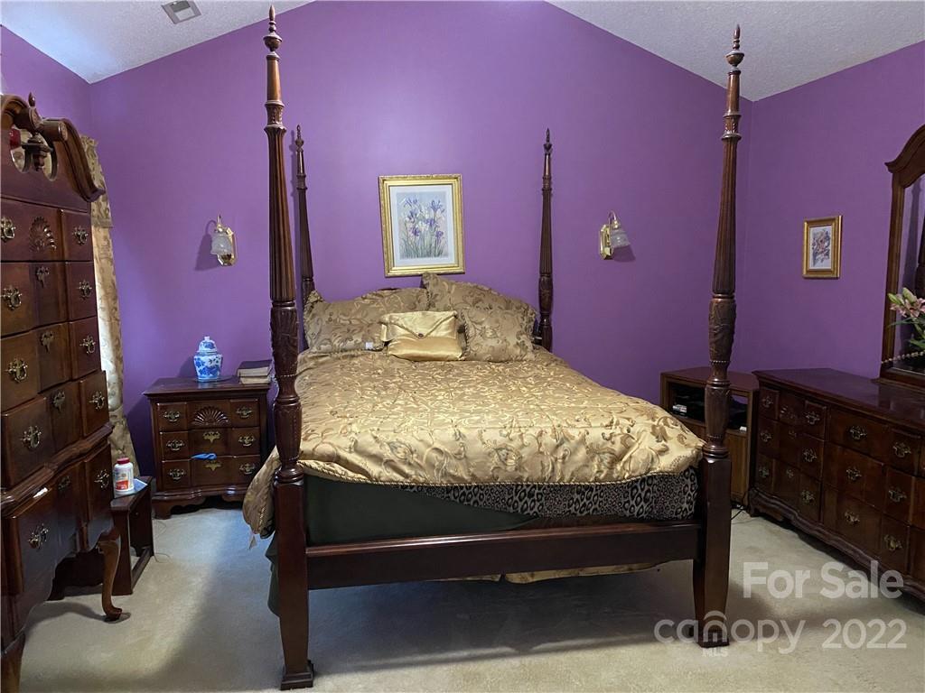 7306 Reedy Creek Road Charlotte, NC 28215 - Photo 8 of 15 a bed sitting in a bedroom next to a window